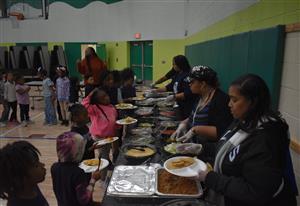 students standing in line to receive nacho toppings